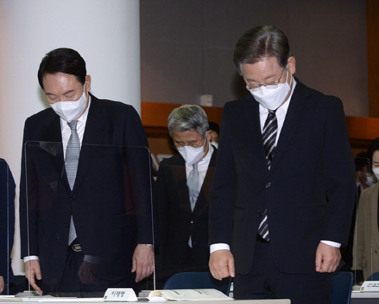 지난 12월9일 이재명(오른쪽) 더불어민주당 대선후보와 윤석열 국민의힘 대선후보가 서울 마포구 연세대 김대중도서관에서 열린 '김대중 대통령 노벨평화상 수상 21주년 기념식 및 학술회의'에서 묵념하고 있다.연합뉴스